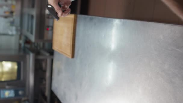 Primo piano del cuoco maschio irriconoscibile che disinfetta e pulisce la superficie del tavolo da cucina in metallo spruzzandola con disinfettante - Filmati, video