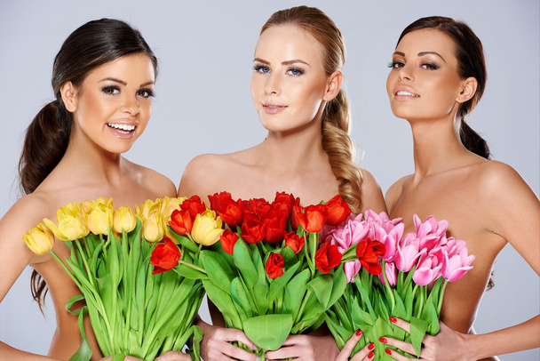 Three beautiful women with fresh spring tulips - Photo, Image