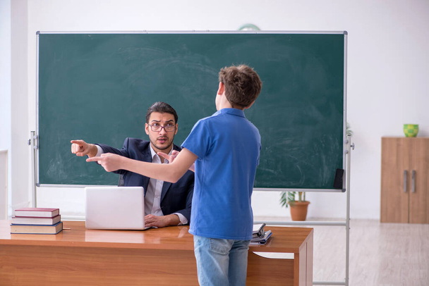 Young male teacher and schoolboy in the classroom - Photo, Image