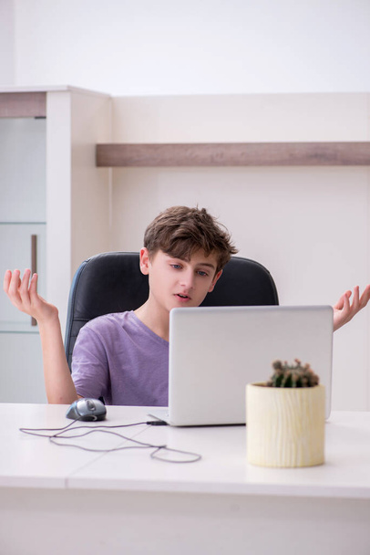 Schoolboy playing computer games at home - Fotó, kép