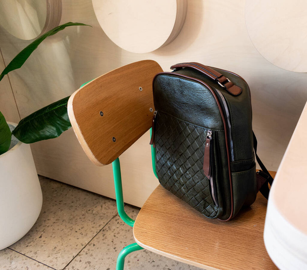 Eco-leather backpack sits on a chair in a public cafe. Eco-friendly concept - Foto, imagen