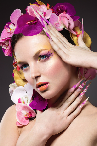Beautiful woman with hair made of flowers and long nails - Foto, Imagem