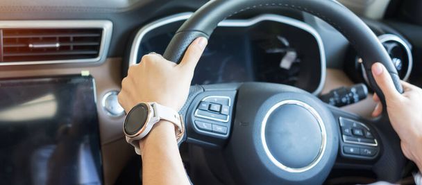 woman driver driving a car on the road, hand controlling steering wheel in electric modern automobile. Journey, trip and Transportation concepts - Photo, Image