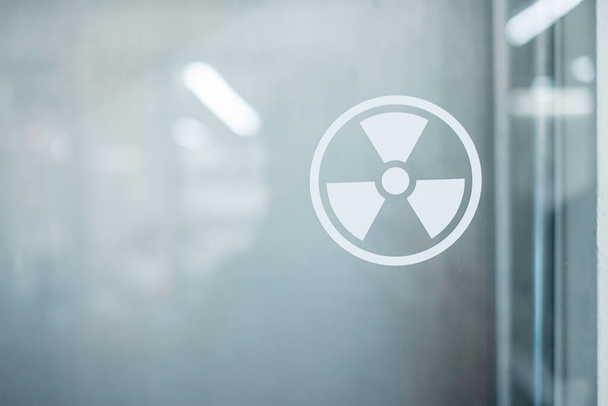 Pegatina de señal de zona de radiación en la ventana de la sala de laboratorio. Concepto de salud y seguridad - Foto, Imagen