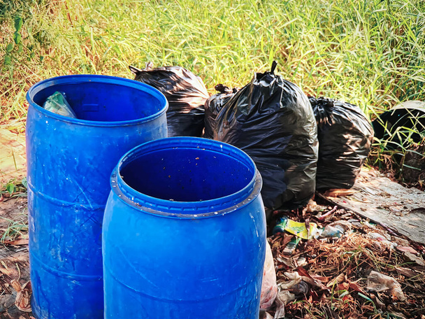 Grupo de papeleras de plástico azul y bolsas de basura negras atadas - Foto, imagen