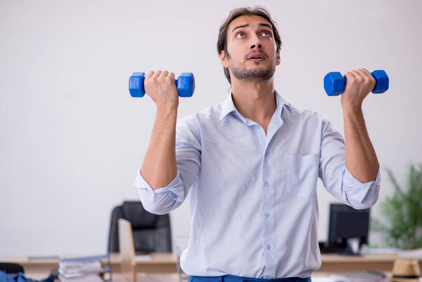 Young male employee doing sport exercises during break - Photo, Image