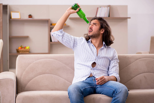 家で酒を飲む若い男 - 写真・画像