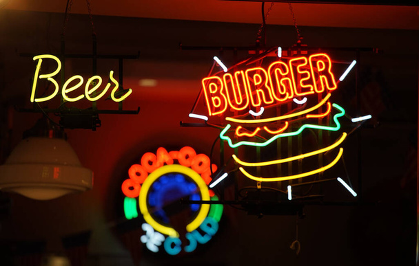 Vista notturna di colorati neon segni di ristoranti per le strade della città                                - Foto, immagini