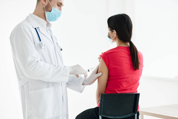 médecin masculin avec une seringue dans les mains faire une injection chez les patients vaccination des épaules - Photo, image