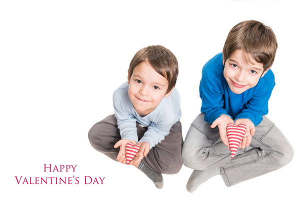 Two brothers holding heart in hands. Isolated on a white background - Photo, image
