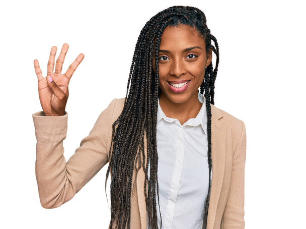 Африканська американка в діловій куртці показує і вказує вгору пальцем номер чотири, посміхаючись впевнено і щасливо.  - Фото, зображення