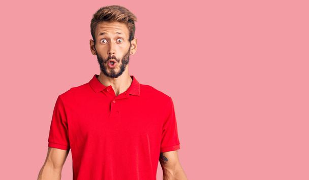 Handsome blond man with beard wearing casual clothes afraid and shocked with surprise expression, fear and excited face.  - Photo, Image