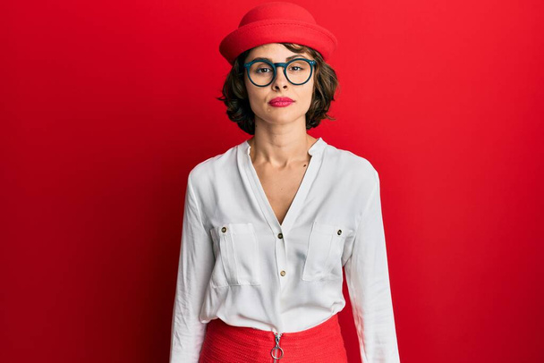 Young brunette woman wearing stewardess style and glasses with serious expression on face. simple and natural looking at the camera.  - Photo, Image