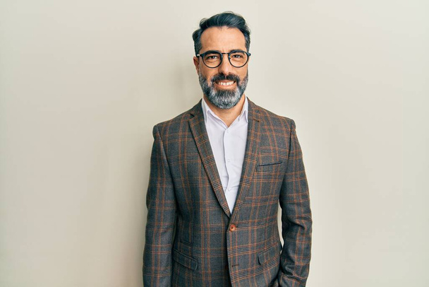 Middle age man with beard and grey hair wearing business jacket and glasses with a happy and cool smile on face. lucky person.  - Foto, afbeelding
