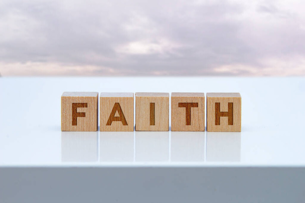 Sinal de mensagem 'Faith' em blocos de madeira sentados em uma mesa branca. - Foto, Imagem