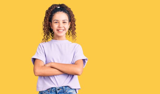 Beautiful kid girl with curly hair wearing casual clothes happy face smiling with crossed arms looking at the camera. positive person.  - Photo, Image