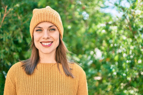 Giovane donna bionda con indosso stile invernale sorridente felice al parco, - Foto, immagini