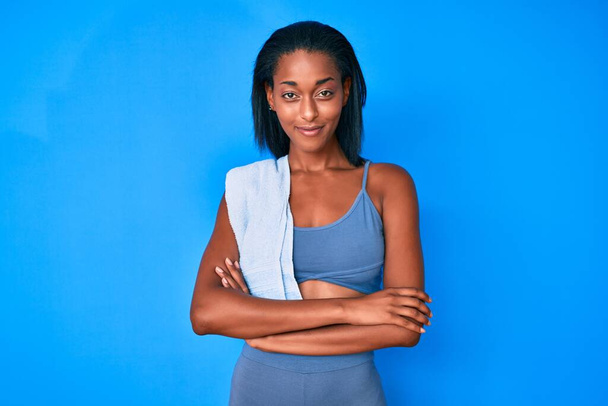 Jeune femme afro-américaine portant des vêtements de sport heureux visage souriant avec les bras croisés en regardant la caméra. personne positive.  - Photo, image