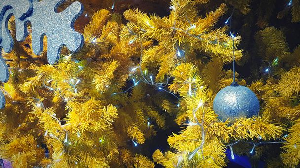 Sarı çam ağacına süslenmiş gümüş top ve beyaz ışık. Mutlu yıllar, Noel ve Kış Festivali konsepti - Fotoğraf, Görsel