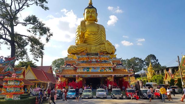 Nakhon Nayok, Thailand -December 5, 2020: Austin Mini cooper and classic car parked in Thai temple with golden buddha statue and blue sky background. Transportation, Religion and Group of old vehicle. - Photo, Image