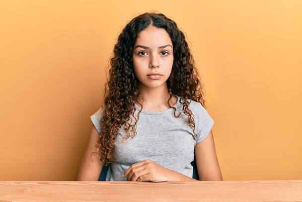 Teenager hispanic girl wearing casual clothes sitting on the table looking sleepy and tired, exhausted for fatigue and hangover, lazy eyes in the morning.  - Foto, immagini