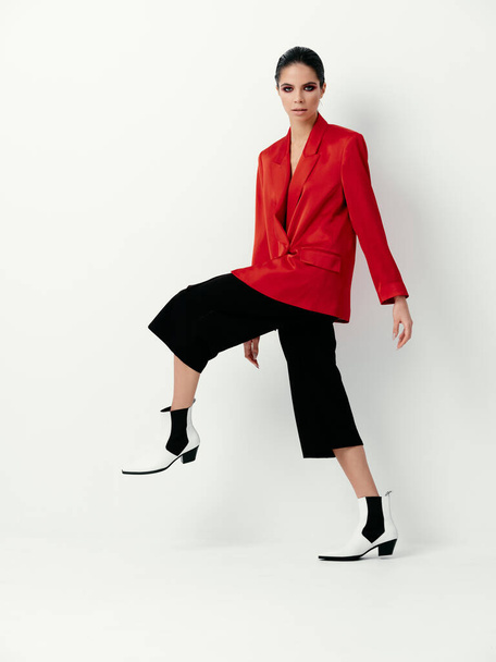 μοντέρνα γυναίκα σε κόκκινο σακάκι μαύρο παντελόνι παπούτσια μοντέλο - Φωτογραφία, εικόνα