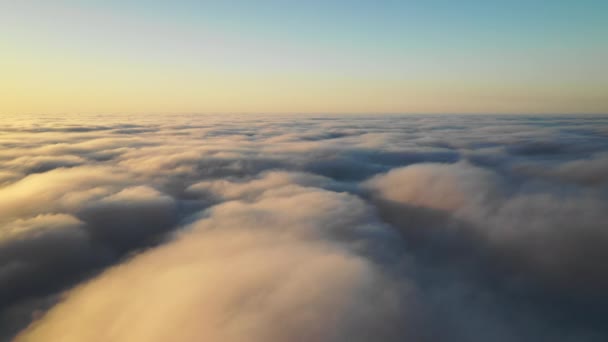 Widok z lotu ptaka nad białymi chmurami o wschodzie słońca  - Materiał filmowy, wideo