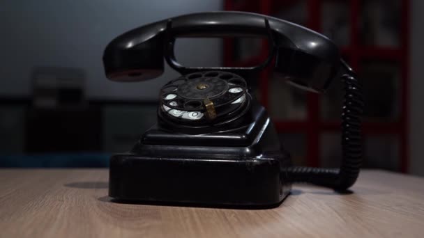 old Soviet telephone of black color stands on a wooden table - Footage, Video