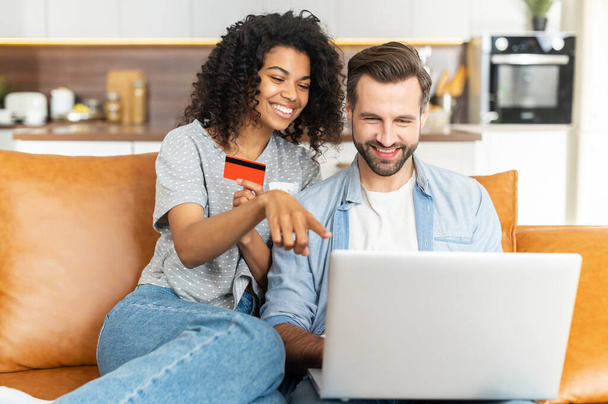 Multiracial couple with a laptop on the couch - Photo, Image