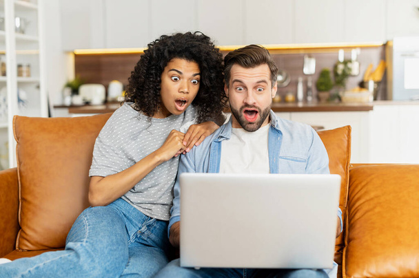 Multiracial couple with a laptop on the couch - Foto, imagen