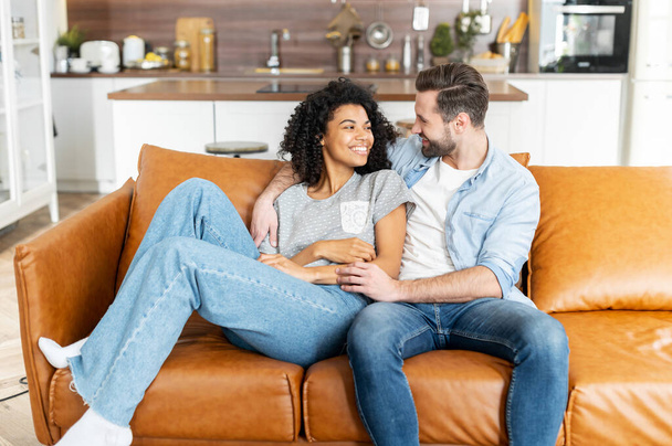 Multiracial couple in love on the couch - 写真・画像
