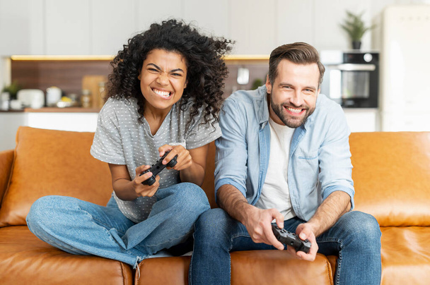 Multiracial couple playing on the console - Фото, зображення