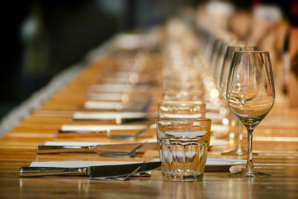 A selective focus shot of long row restaurant table setting perspective view - Foto, Imagen