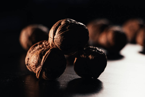 The walnuts on a wooden surface in a dark background - Фото, зображення