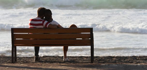 Silueta pareja romántica en un banco junto al mar - Foto, Imagen