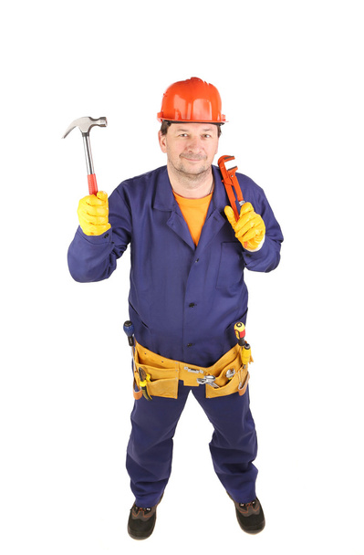 Worker in protective helmet holding hammer. - 写真・画像