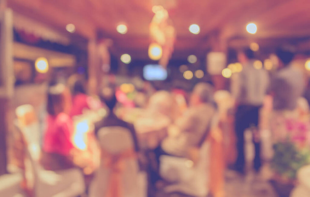 Imagem borrada abstrato de grande mesa de jantar para casamento, jantar ou evento do festival com belas luzes decoração dentro de grande salão para uso em segundo plano. (tom vintage) - Foto, Imagem
