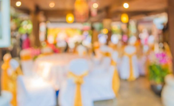 Düğün, akşam yemeği ya da festival etkinliği için hazırlanmış arka plan kullanımı için büyük salonun içindeki güzel ışıklandırma dekorasyonlu büyük yemek masasının soyut bulanık görüntüsü . - Fotoğraf, Görsel