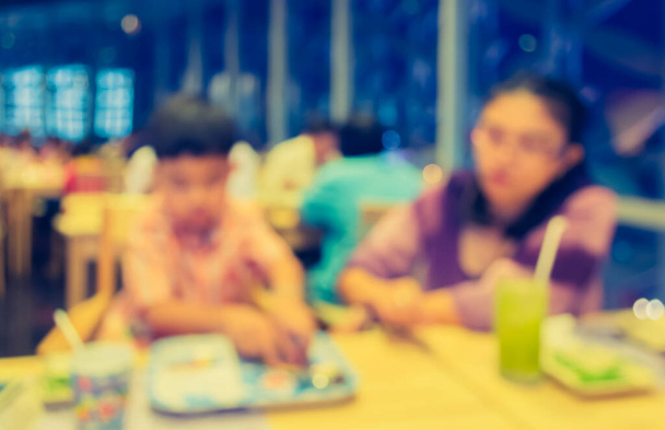 imagen de personas desenfocadas abstractas sentadas en un restaurante o cafetería para uso de fondo. (tono vintage) - Foto, imagen