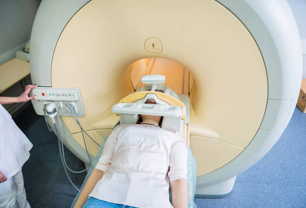Radiologist prepares the young woman for an MRI brain examination - Φωτογραφία, εικόνα