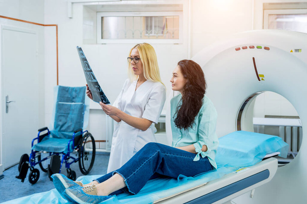 Radiologist with a female patient examining a CT scan - Valokuva, kuva