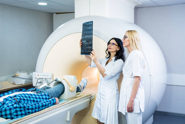 Radiologist with a male patient examining a mri scan - Фото, зображення