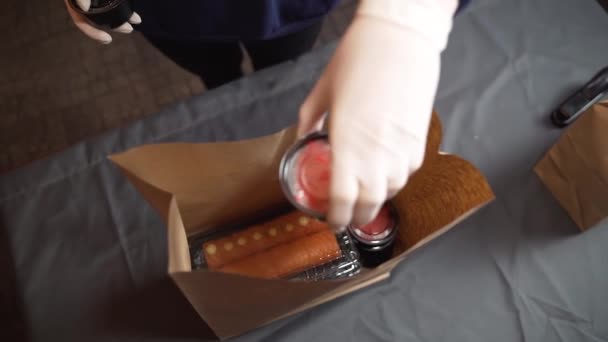 Σούσι συσκευασία για την παράδοση, μια γυναίκα βάζει ένα σετ σούσι και σάλτσα σε μια τσάντα σκάφος - Πλάνα, βίντεο