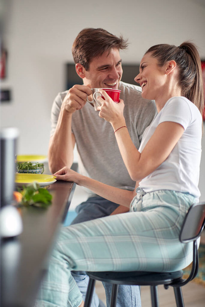 A young couple in love enjoying a coffee before breakfast in a cheerful atmosphere at home. Couple, love, breakfast, together - Foto, Imagem