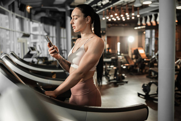 Young beautiful caucasian fit strong woman is doing exercises in gym - Fotoğraf, Görsel