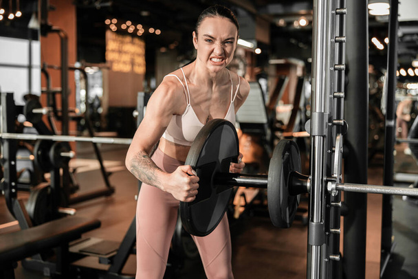 Young beautiful caucasian fit strong woman is doing exercises in gym - Photo, Image