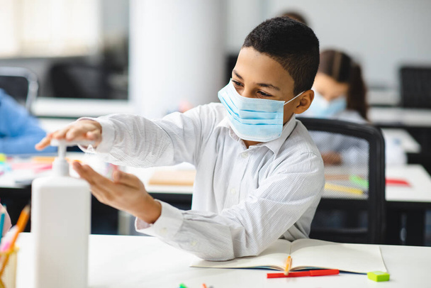Small boy applying antibacterial sanitizer on hands - Фото, зображення