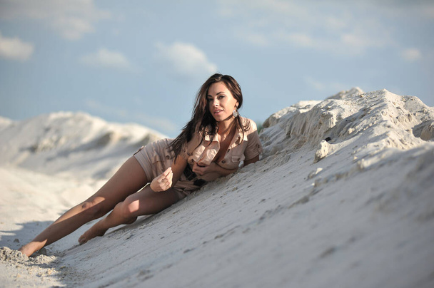 Bella giovane donna in biege vestiti estivi sulla sabbia - Foto, immagini