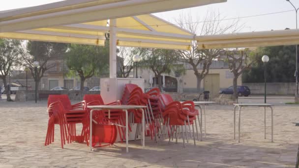 Červené plastové židle naskládané před jídelnou, kterou uzavřela koronavirová krize. Omezení v restaurování Covid-19 - Záběry, video