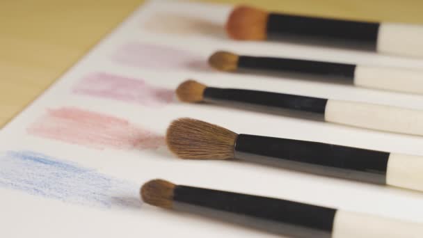 πινέλα μακιγιάζ σε μια σειρά σε ένα χαρτί με δείγματα χρωμάτων - Πλάνα, βίντεο